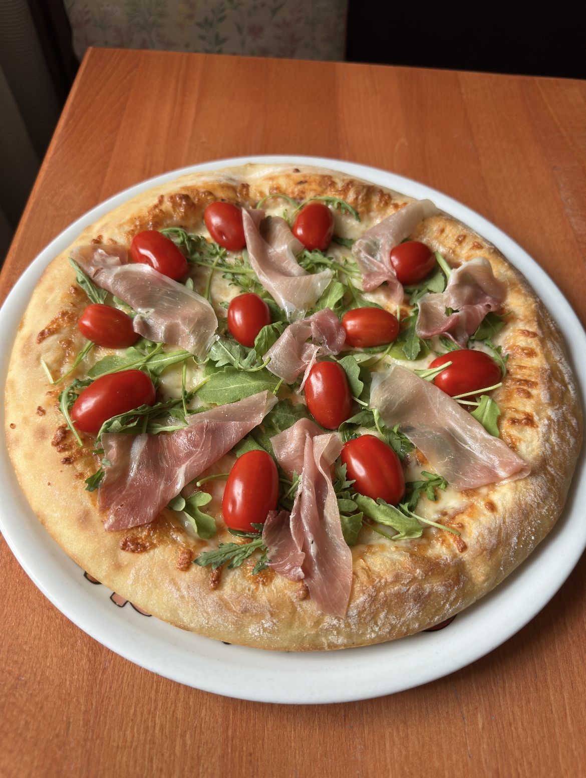 Pizza Parmeńska z szynką parmeńską, rukolą i pomidorkami koktajlowymi